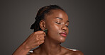 Black woman, skincare and facial treatment with gua sha for massage on a gray studio background. Female person, model or relaxation with tool for collagen, lymphatic drainage or dermatology on space