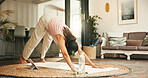 Woman, stretching and yoga for fitness at house with exercise, body balance and core strength. Female person, downward pose and muscle warm up for flexibility, circulation and wellness hobby in home
