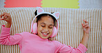 Top view, headphones and happy kid on bed for music, streaming service and relax with audio. Dance, above and girl in bedroom for song, online radio and child listening to sound on weekend in home