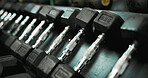 Fitness, equipment and dumbbells on rack at gym for weightlifting, strength training or workout. Closeup, row and steel weights at health club for resistance exercise, bodybuilding and muscle growth