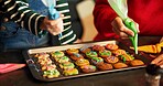 Christmas, helping hand or kid in house with icing, baking or bonding together in holiday season. Christmas, learning or family in home with cookie, connection or sweet treat frosting for Santa.