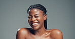 Happy, black woman and laughing with skincare in studio for glow or shine on a gray background. Female person, model or smile with beauty, comedy or humor for anti aging skin or treatment on space