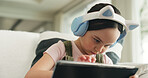 Headphones, kid or elearning with tablet on couch, concentration or school website for education task. Homework, class live stream or girl with digital app for teaching video, low angle or audio tech
