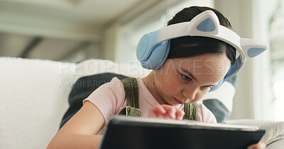 Buy stock photo Headphones, kid or elearning with tablet on couch, concentration or school website for education task. Homework, class live stream or girl with digital app for teaching video, low angle or audio tech