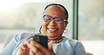 African old woman, smile and phone at house for research, browsing social media and funny video. Happy, senior person and laughing with mobile, message and download games for retirement entertainment