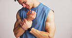 Fitness, man or wrist pain in studio from workout challenge, sports injury or bodybuilding accident. Hurt, person and athlete with joint inflammation, arthritis relief or massage on white background.
