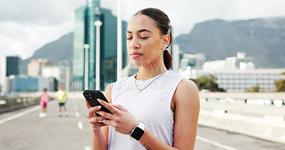 Buy stock photo Woman, runner and phone with texting in city, bridge and break with notification, fitness and training. Person, smartphone and scroll on mobile app with search for exercise tips in town with routine