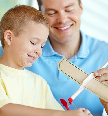 Buy stock photo Airplane, playing and child and dad with toys for fun for bonding, relationship and creativity. Family, happy and boy building model aeroplane with father for games, entertainment and relax in home
