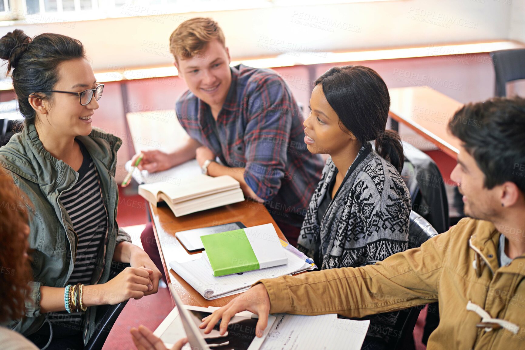Buy stock photo Students, group and studying in discussion with books, tablet and diversity in library for education. Men, women and friends at university, tech and talking for solution, planning and ready for exam