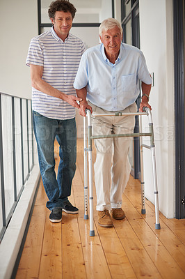 Buy stock photo Son, helping and old man with disability in home for love, physical support and bonding. Portrait, family or senior father with walker for assistance, mobility balance and guidance for rehabilitation
