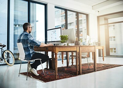 Buy stock photo Full length shot of a businessman working on his computer in the office
