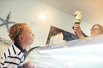 Buy stock photo Ice cream, happy and child in store for dessert with worker serving dessert for sweet treat. Excited, craving and server with scoop of frozen gelato in cone for boy kid customer in dairy shop.