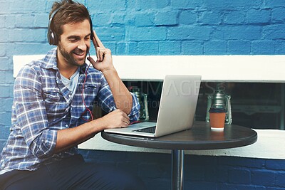 Buy stock photo Headphones, music and happy man on laptop at cafe for remote work, sound or streaming radio at table. Computer, audio and freelancer in coffee shop for social media, podcast and listening to jazz