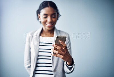 Buy stock photo Business woman, phone and text for social media, internet and app on mobile in studio. Website, online and digital creative writer at seo company with young professional and tech with grey background
