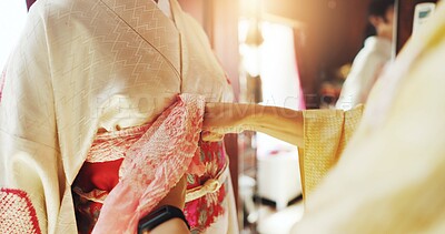 Buy stock photo Kimono, dressing and help with hands of people at tailor in japan for designer, dressmaking and fashion. Festive ceremony, culture and traditional clothes with closeup of obi belt for fabric shop