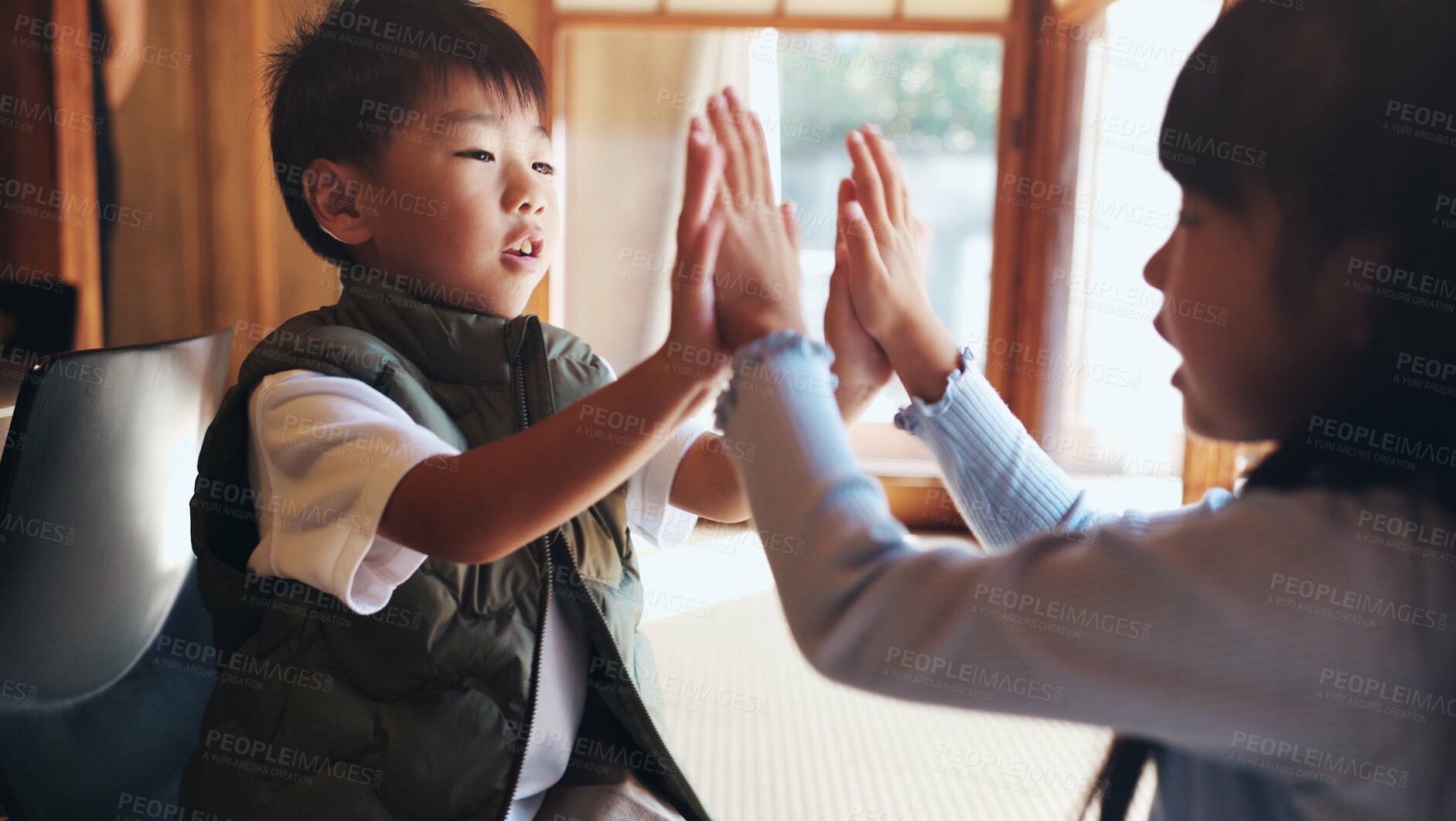 Buy stock photo Home, children and playing clapping game for bonding, cognitive development and coordination. Japanese people, kids and fun activity in living room for learning, interaction and motor skills on floor
