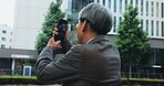 Outdoor, businessman and photography with smartphone in city for infrastructure development project in Japan. Mature person, employee and property developer in downtown for architect design and ideas
