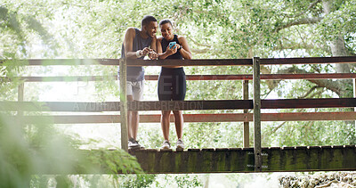 Buy stock photo Bridge, smile and couple with cellphone, fitness and bonding together with social media. Funny meme, outdoor and man in park, healthy woman and smartphone with training, laughing and digital app