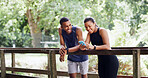 Hiking, nature or happy people with phone on bridge, outdoor exercise or digital map for trail navigation. Fitness, track steps and friends with mobile location app, fauna and flora research on break