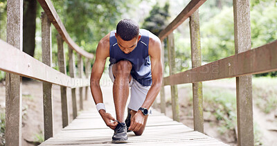 Buy stock photo Man, runner and tie shoelaces at park for fitness routine, wellness or ready for workout on bridge. Person, outdoor and prepare on ground for sport shoes, exercise or training challenge in Costa Rica