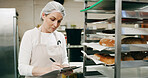 Restaurant, pastry chef and woman in commercial kitchen with document, checklist and bread. Baker person, paperwork and stock for catering, bakery industry and production for breakfast or snack