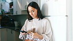 Woman, phone and texting in kitchen with smoothie, drink and glass for gut health with web chat in home. Person, smartphone and scroll on mobile app, contact or social media with nutrition in house