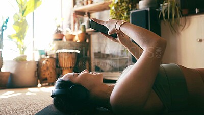 Buy stock photo Yoga, headphones and reading with woman on floor for guided meditation, streaming and wellness podcast. Connection, zen and calm sound with person in home for fitness, subscription and phone