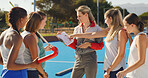 Athlete pointing, clipboard and strategy with coach for hockey match, tournament and competition. Instructor, people and talk on turf with game plan for tactical feedback, sports formation and ideas.