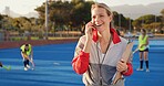 Coach, hockey and happy woman with phone call for match organization, conversation and event info.Planning, mobile and sport trainer with clipboard on turf, game arrangement and local league opponent
