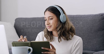 Buy stock photo Woman, book and writing with headphones in home for elearning subscription, laptop and education. Person, computer and student with notebook, attention and online course in living room at apartment