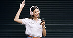 Happy woman, listening and music with headphones or phone for vibe in studio on a dark background. Excited, female person or model dancing with smile or mobile smartphone for audio streaming on space