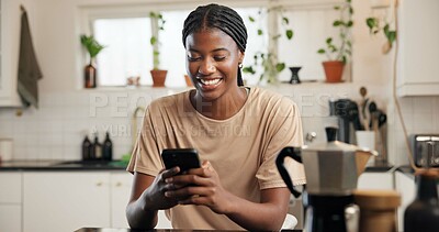 Buy stock photo Black woman, phone and happy with texting in kitchen, contact or funny video on web at apartment. African person, smartphone and smile for notification, chat or social network with meme in house