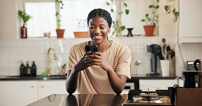 Buy stock photo Phone, smile and text message with black woman in kitchen of home for social media browsing. App, communication and typing with happy African person in apartment for contact, scrolling or search