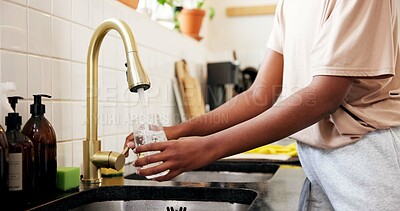 Buy stock photo Home, kitchen and hands with tap water in glass for hydration, natural nutrients or thirsty. Mineral, person and pouring liquid at faucet for refreshing drink, wellness beverage and digestive health