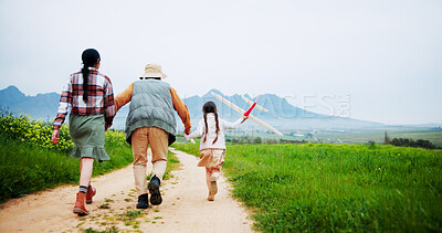 Buy stock photo Holding hands, parents or child with kite in countryside for bonding, love or play outside for vacation. Connection, grass field or happy people support girl on holiday, back or space on weekend