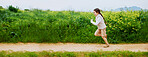 Energy, running and space with girl outdoor in countryside for child development or growth. Adventure, excited and path with happy kid in green nature for activity, journey or wilderness experience