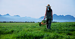 Farm, walking and back of woman with vegetables for growth, healthy crops and harvest. Agriculture, space and person with basket for environment, ecology and organic produce for sustainability