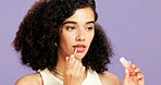 Beauty, cosmetics and lip gloss with woman in studio for hydration or moisturizer application. Aesthetic, mouth product and skincare with African model isolated on purple background for dermatology