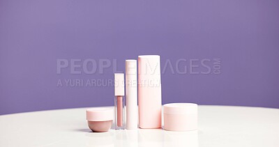 Buy stock photo Makeup, bottles and product range in studio for beauty aesthetic, skincare routine and marketing. Space, cosmetic selection or container for dermatology, wellness or advertising on purple background.