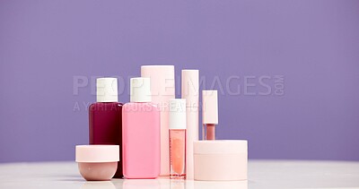 Buy stock photo Makeup, container and product range in studio for beauty aesthetic, skincare routine and marketing. Space, cosmetic selection or bottles for dermatology, wellness or advertising on purple background.