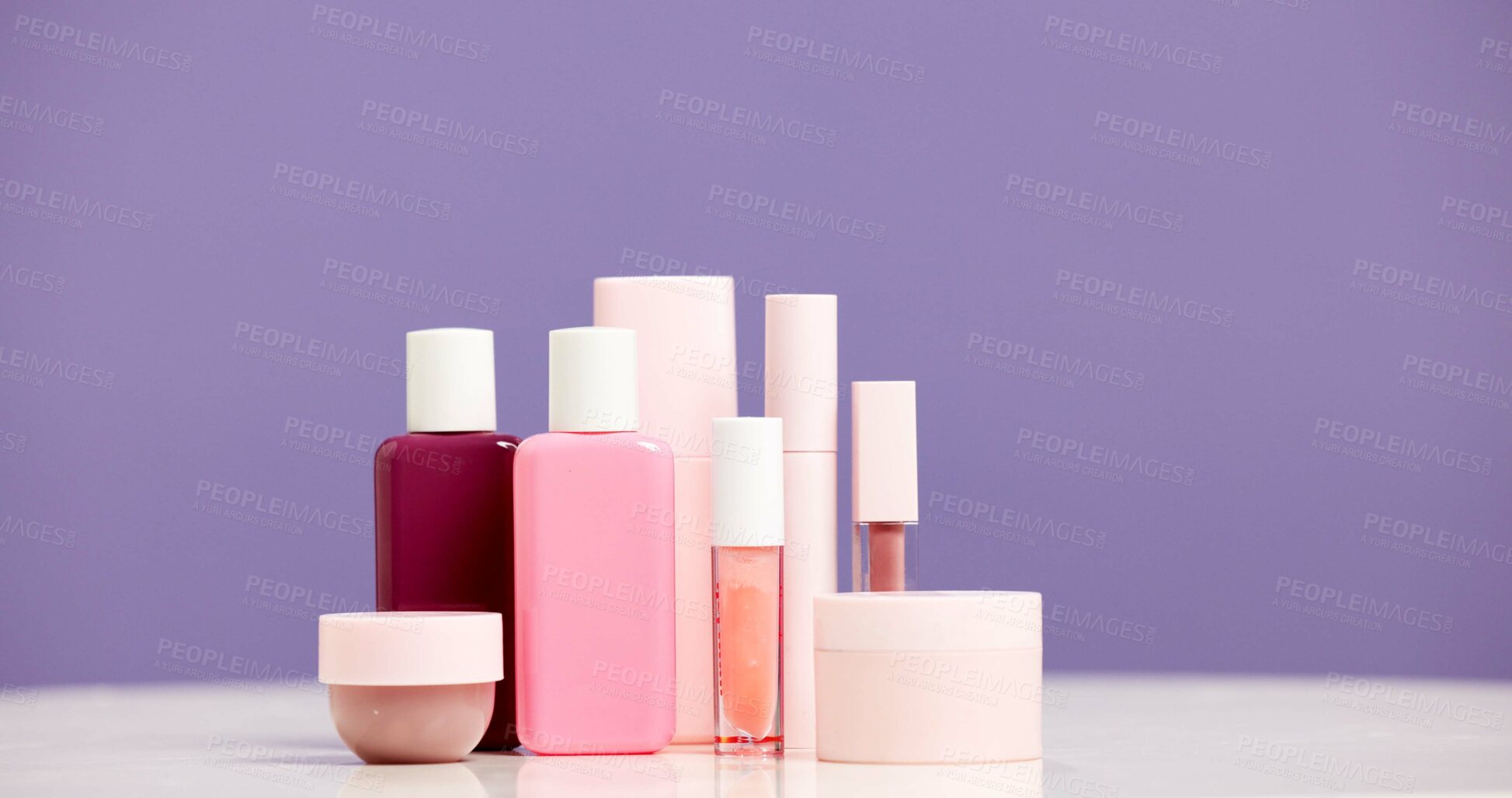 Buy stock photo Makeup, container and product range in studio for beauty aesthetic, skincare routine and marketing. Space, cosmetic selection or bottles for dermatology, wellness or advertising on purple background.