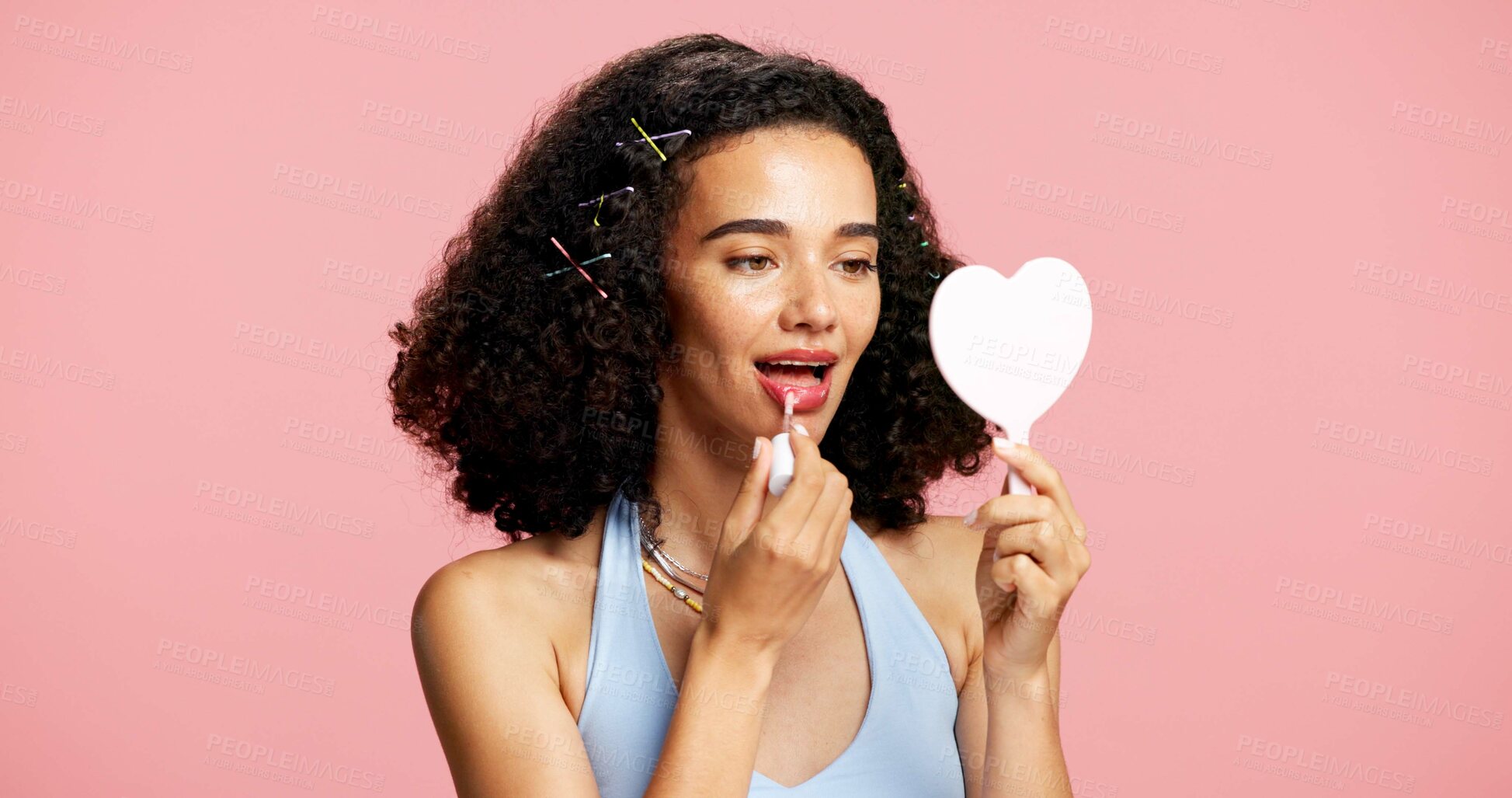 Buy stock photo Cosmetics, mirror and woman apply lip gloss in studio, color product and moisturizing benefits in shine. Lipstick, beauty aesthetic and person with hydrating makeup for glow, space or pink background