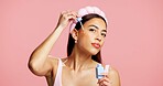 Portrait, apply serum and woman in studio for skincare, beauty treatment and product for healthy glow. Clear skin, headband and person with hyaluronic acid for hydration, space and pink background