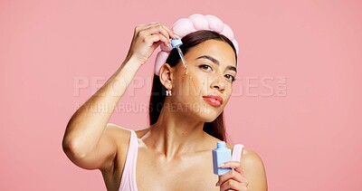 Buy stock photo Portrait, apply serum and woman in studio for skincare, beauty treatment and product for healthy glow. Clear skin, headband and person with hyaluronic acid for hydration, space and pink background