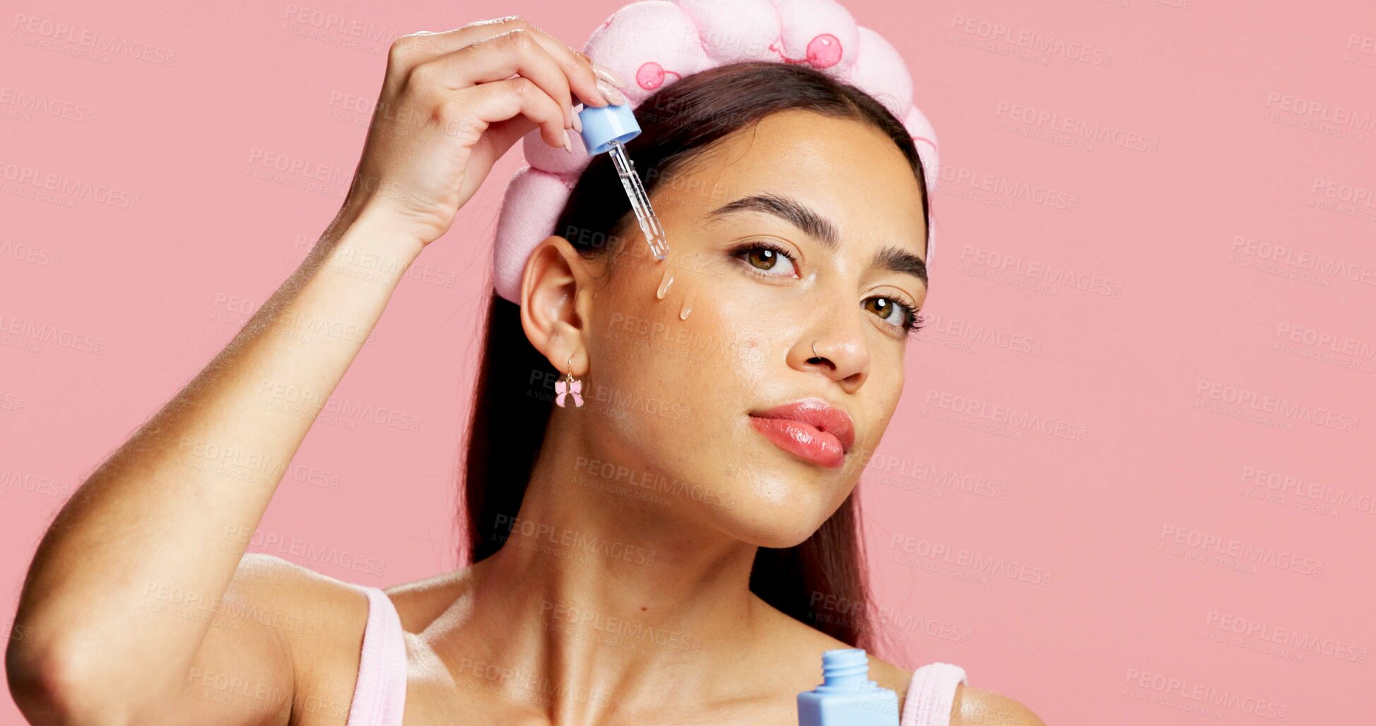 Buy stock photo Portrait, serum application or woman in studio for skincare, beauty treatment or product for healthy glow. Clear skin, headband or person with hyaluronic acid for hydration, space or pink background