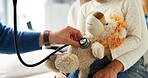 Stuffed animal, stethoscope and hands with child in hospital for heartbeat, consulting and arrhythmia symptom. Medical advice, cardiology and pediatrician with people in clinic for support and toy