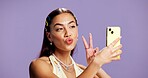 Beauty, peace sign and selfie with influencer woman in studio for product review on social media. App, haircare and pout of playful content creator isolated on purple background for post or update