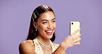 Beauty, selfie and smile with influencer woman in studio for product review on social media. App, haircare and happy with excited content creator isolated on purple background for post or update