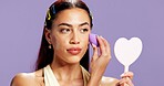 Beauty, mirror and sponge with woman in studio for cosmetics, contour and makeup maintenance. Self care, glow and blush with person on purple background for highlighter shine, foundation and gen z