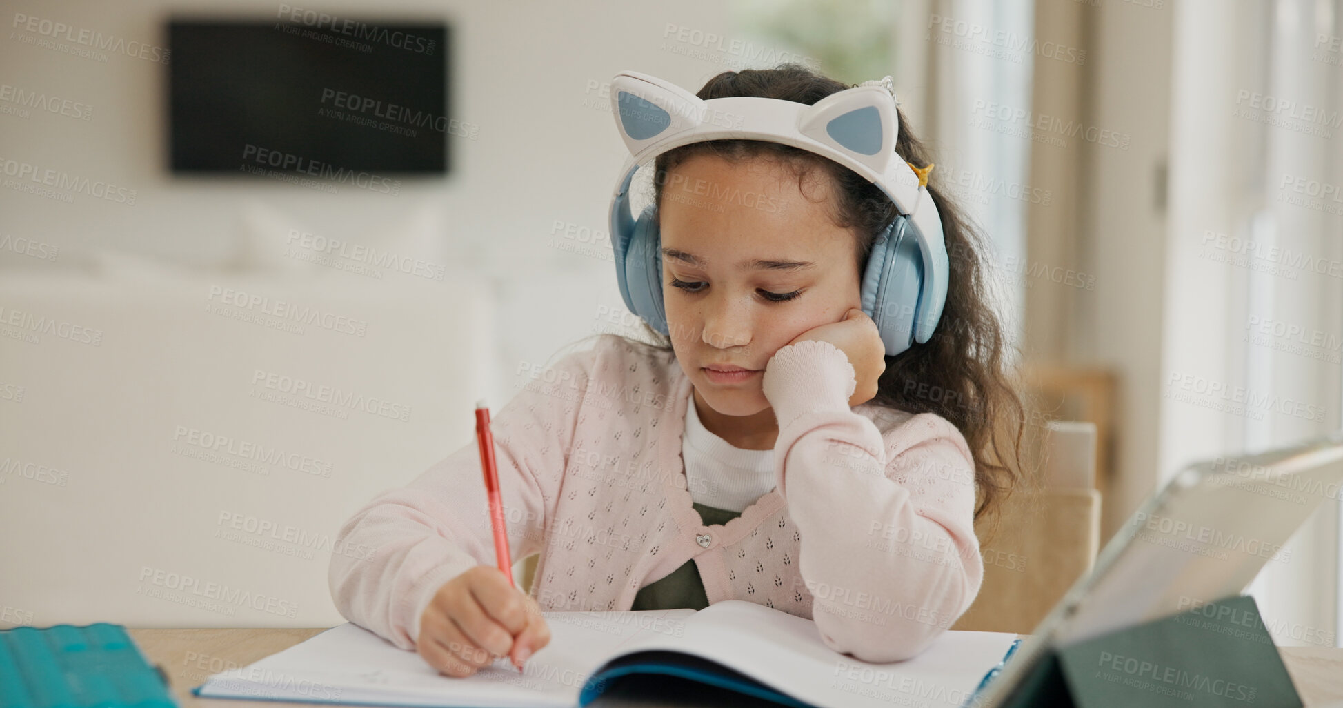 Buy stock photo Home, elearning and child with headphones, writing and listening to audio lesson, knowledge or study. Student, serious and girl with tech for homework, growth and development with online education